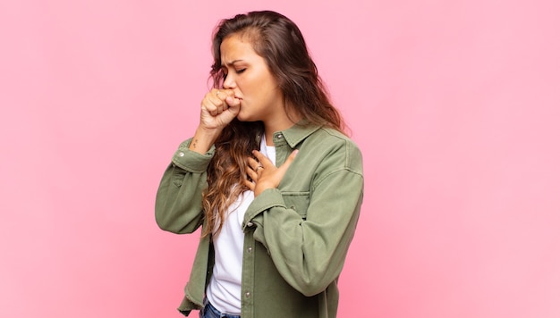 Foto joven mujer bonita tosiendo sobre fondo rosa