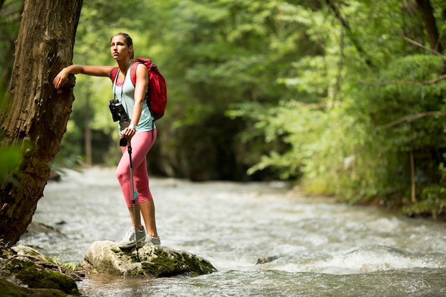 Joven mujer caminando por el río