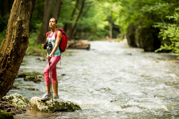 Joven mujer caminando por el río