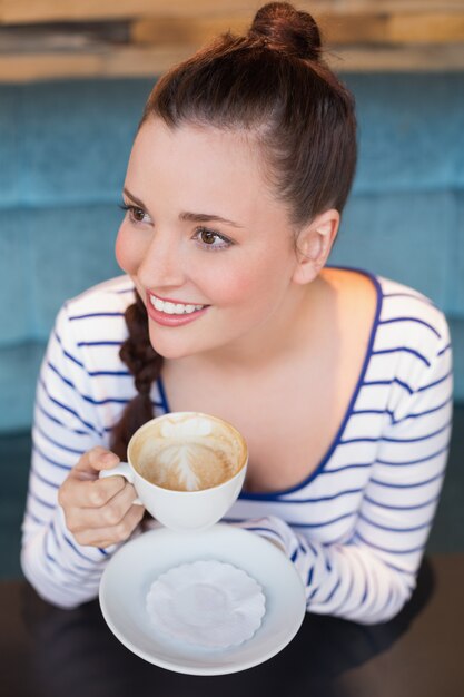 Joven mujer con un capuchino en el café