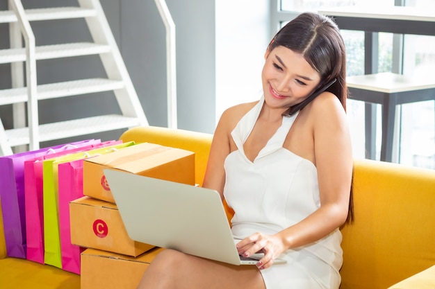 Joven mujer casual asiática trabajando emprendedor pequeña empresa emprendedora PYME en la tienda de ropa