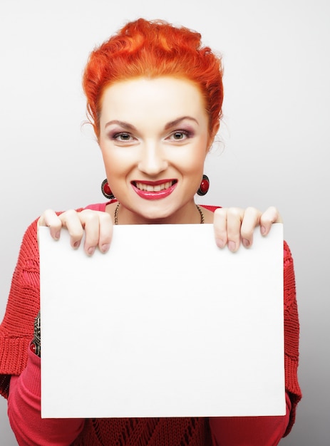 Joven mujer casual feliz con cartel en blanco