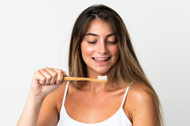 Joven mujer caucásica aislada en blanco con un cepillo de dientes