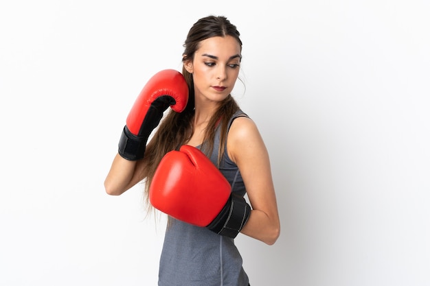 Joven mujer caucásica aislada en blanco con guantes de boxeo