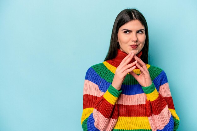 Joven mujer caucásica aislada de fondo azul inventando un plan en mente creando una idea