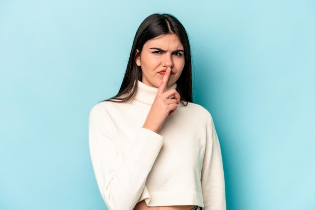 Joven mujer caucásica aislada de fondo azul pensando y mirando hacia arriba siendo reflexiva contemplando tener una fantasía