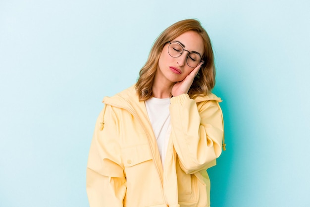 Joven mujer caucásica aislada de fondo azul que está aburrida, fatigada y necesita un día de relajación.