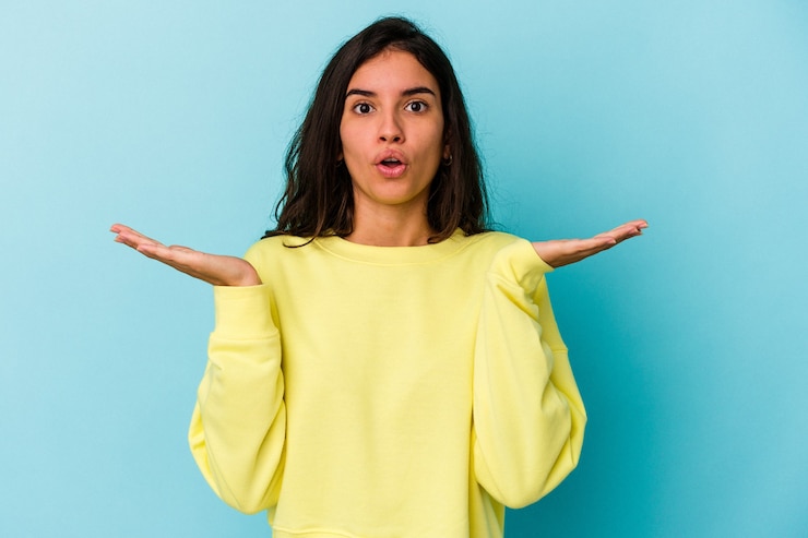 Foto joven mujer caucásica aislada de fondo azul sorprendida y conmocionada.