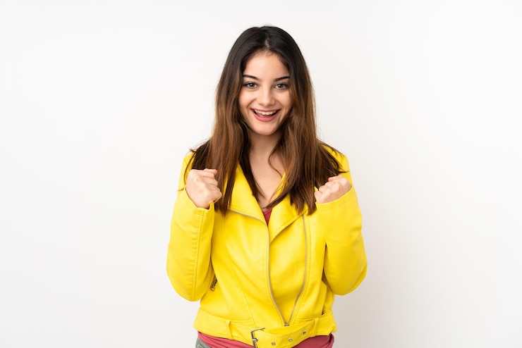Foto joven mujer caucásica aislada en fondo blanco celebrando una victoria en posición de ganadora