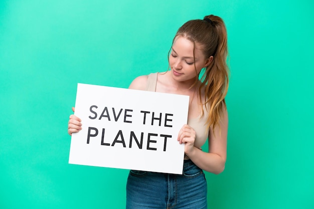 Joven mujer caucásica aislada de fondo verde sosteniendo un cartel con el texto Salvemos el planeta