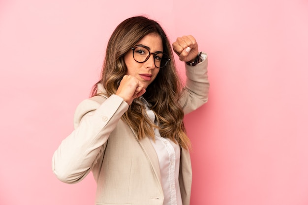 Joven mujer caucásica aislada lanzando un puñetazo, ira, luchando debido a una discusión, boxeo.