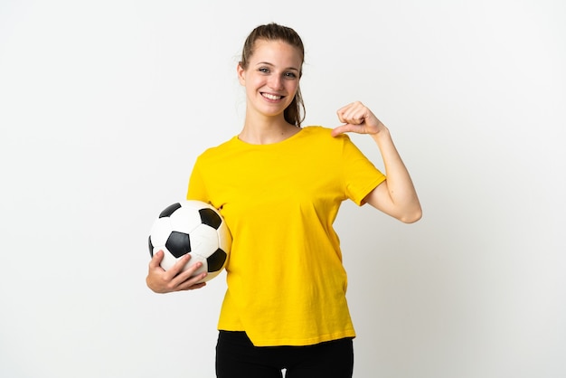 Joven mujer caucásica aislada en la pared blanca con balón de fútbol y orgulloso de sí mismo