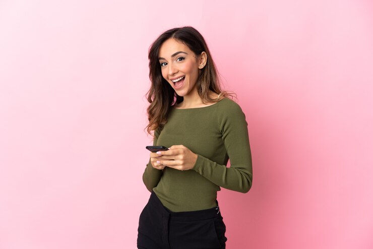 Foto joven mujer caucásica aislada en la pared rosa sorprendida y enviando un mensaje
