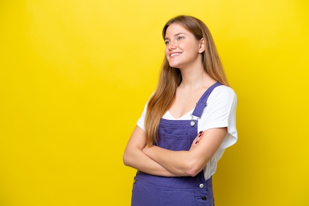 Joven mujer caucásica aislada sobre fondo amarillo feliz y sonriente