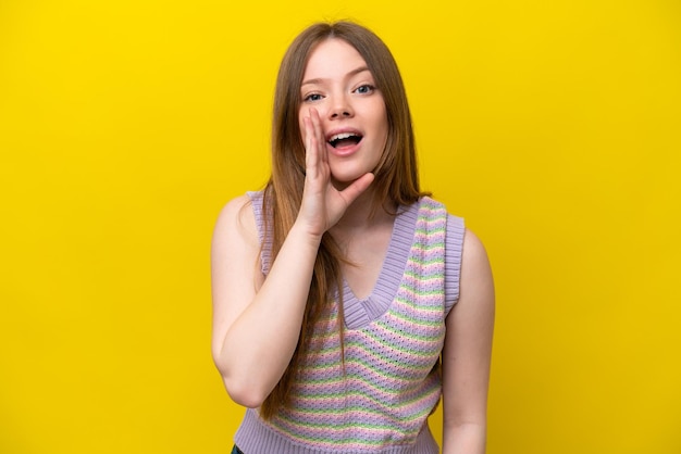 Joven mujer caucásica aislada sobre fondo amarillo gritando con la boca abierta