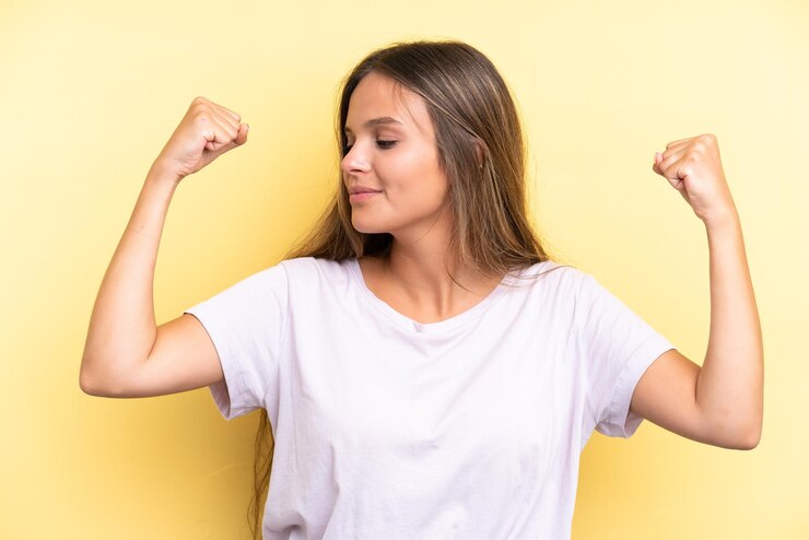 Foto joven mujer caucásica aislada sobre fondo amarillo haciendo gesto fuerte