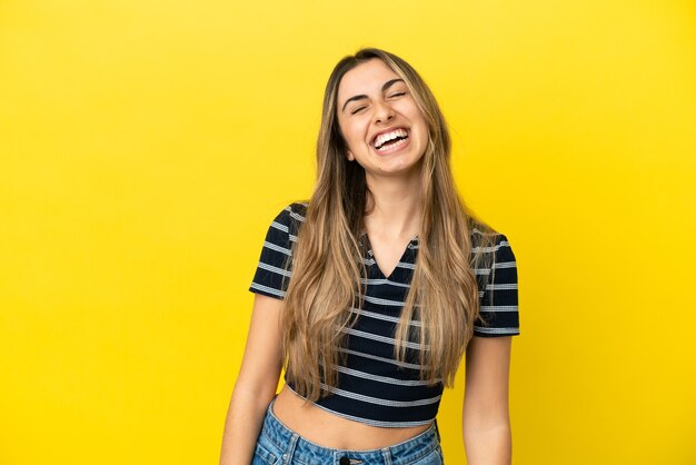 Joven mujer caucásica aislada sobre fondo amarillo riendo