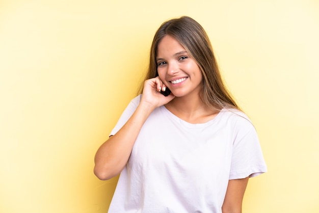 Joven mujer caucásica aislada sobre fondo amarillo riendo