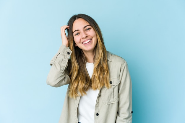 Joven mujer caucásica aislada sobre fondo azul alegre riendo mucho. Concepto de felicidad.