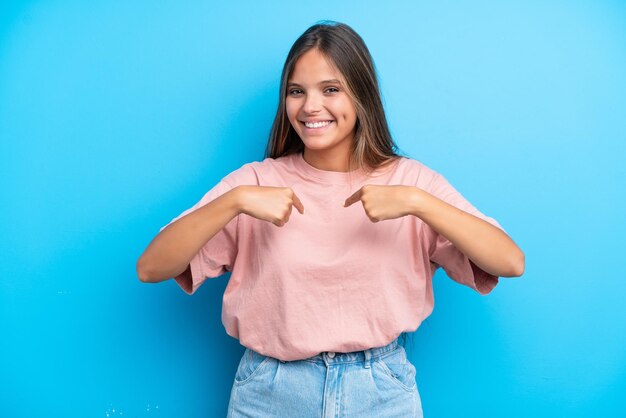 Joven mujer caucásica aislada sobre fondo azul con expresión facial sorpresa