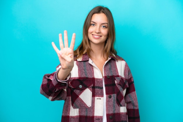 Joven mujer caucásica aislada sobre fondo azul feliz y contando cuatro con los dedos