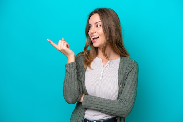 Joven mujer caucásica aislada sobre fondo azul con la intención de darse cuenta de la solución mientras levanta un dedo