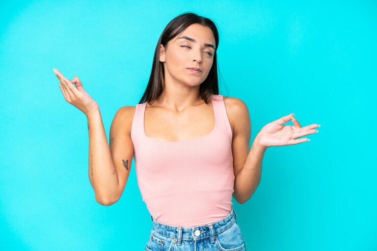 Foto joven mujer caucásica aislada sobre fondo azul en pose zen