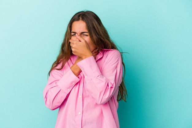 Foto joven mujer caucásica aislada sobre fondo azul sufre dolor de garganta debido a un virus o infección.