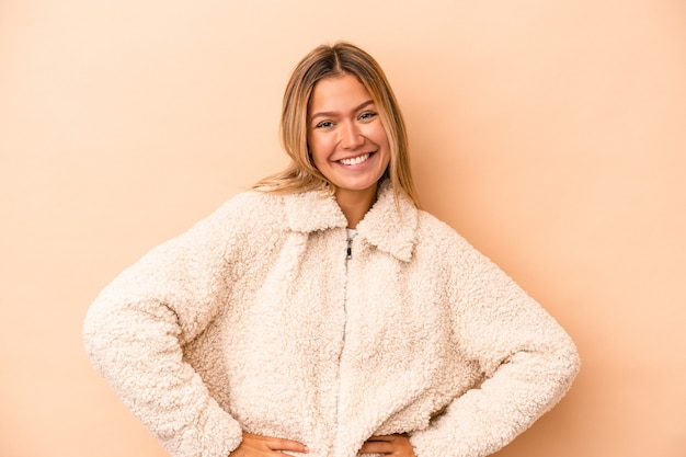 Joven mujer caucásica aislada sobre fondo beige feliz, sonriente y alegre.