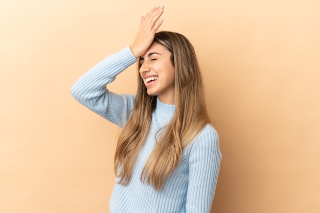 Joven mujer caucásica aislada sobre fondo beige se ha dado cuenta de algo y tiene la intención de la solución