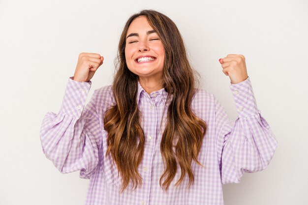 Joven mujer caucásica aislada sobre fondo blanco celebrando una victoria, pasión y entusiasmo, expresión feliz.