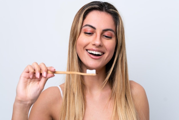 Joven mujer caucásica aislada sobre fondo blanco con un cepillo de dientes