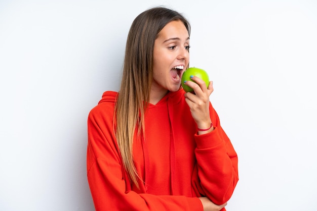 Joven mujer caucásica aislada sobre fondo blanco comiendo una manzana