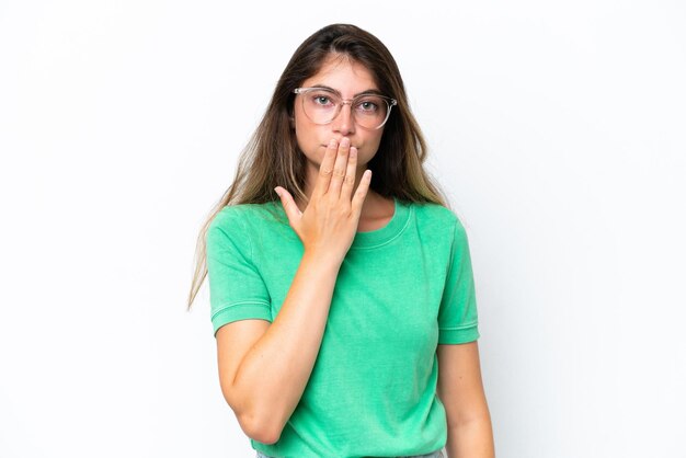 Foto joven mujer caucásica aislada sobre un fondo blanco cubriendo la boca con la mano