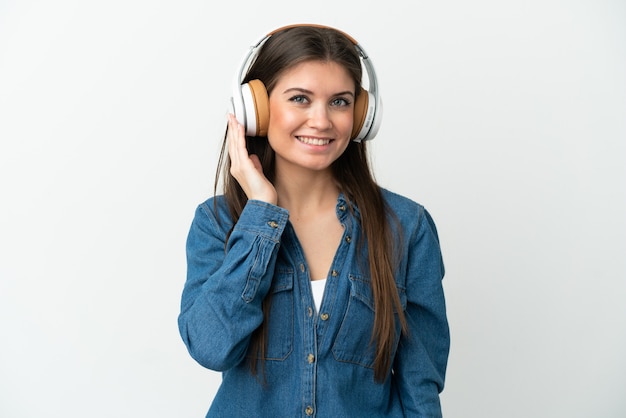 Joven mujer caucásica aislada sobre fondo blanco escuchando música