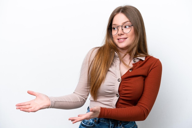 Joven mujer caucásica aislada sobre fondo blanco con expresión de sorpresa mientras mira de lado