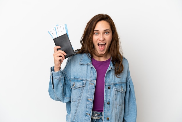 Joven mujer caucásica aislada sobre fondo blanco feliz de vacaciones con pasaporte y billetes de avión