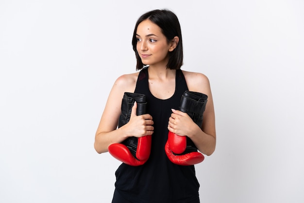 Joven mujer caucásica aislada sobre fondo blanco con guantes de boxeo