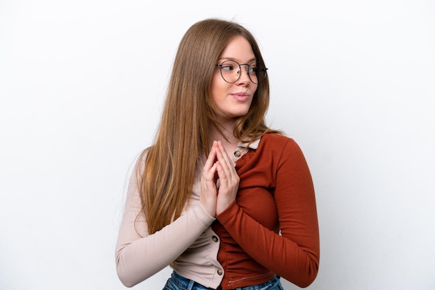 Foto joven mujer caucásica aislada sobre fondo blanco intrigando algo