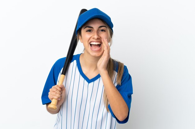 Joven mujer caucásica aislada sobre fondo blanco jugando béisbol y gritando con la boca abierta