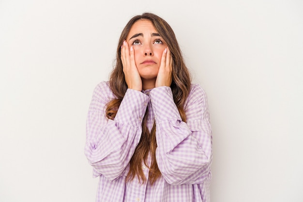 Joven mujer caucásica aislada sobre fondo blanco llorando, infeliz con algo, concepto de agonía y confusión.