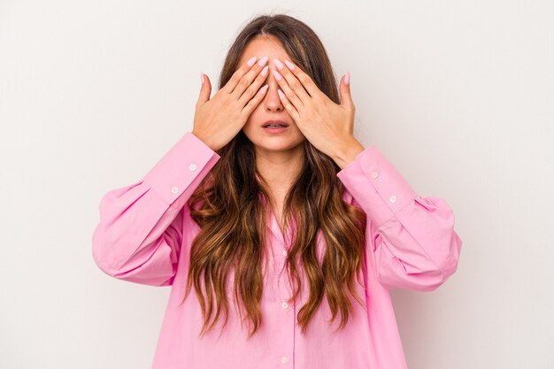 Foto joven mujer caucásica aislada sobre fondo blanco miedo cubrirse los ojos con las manos.