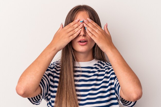 Foto joven mujer caucásica aislada sobre fondo blanco miedo cubrirse los ojos con las manos.