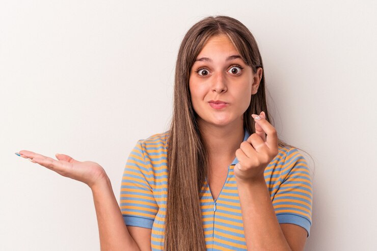 Foto joven mujer caucásica aislada sobre fondo blanco mostrando que no tiene dinero.