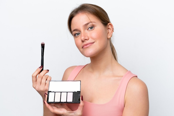 Foto joven mujer caucásica aislada sobre fondo blanco con paleta de maquillaje