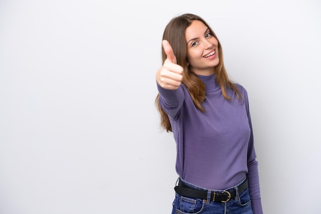 Joven mujer caucásica aislada sobre fondo blanco con los pulgares hacia arriba porque ha sucedido algo bueno