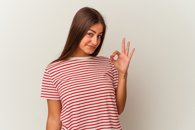 Joven mujer caucásica aislada sobre fondo blanco se ríe y cierra los ojos, se siente relajada y feliz.