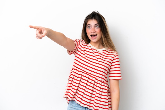 Joven mujer caucásica aislada sobre un fondo blanco señalando hacia otro lado