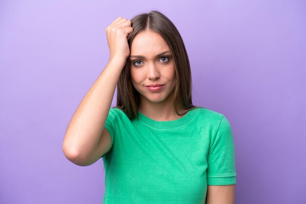 Joven mujer caucásica aislada sobre fondo morado con una expresión de frustración y no comprensión