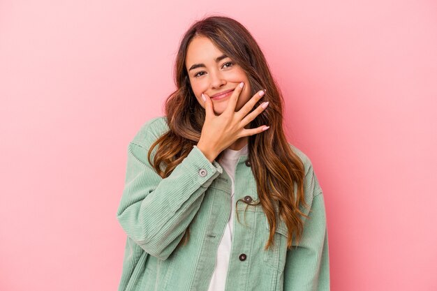 Joven mujer caucásica aislada sobre fondo rosa dudando entre dos opciones.